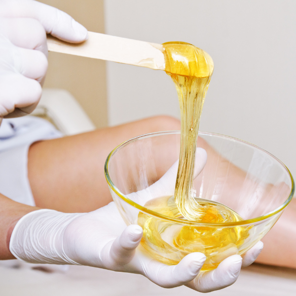 a nail technician carefully removing the cuticles of a customer at a nails salon.